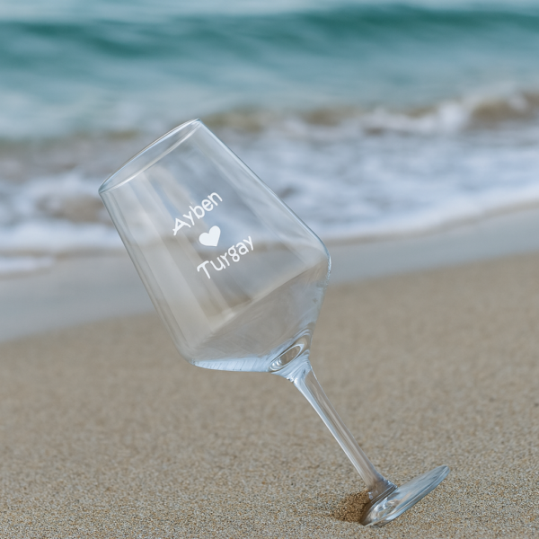 Elegant clear 465 ml wine glasses filled with red wine, laser engraved with custom names and a heart design, displayed on a dining table with flowers, plates, and a wine bottle—perfect personalized gift for Mother’s Day, birthdays, weddings, anniversaries, and special occasions.