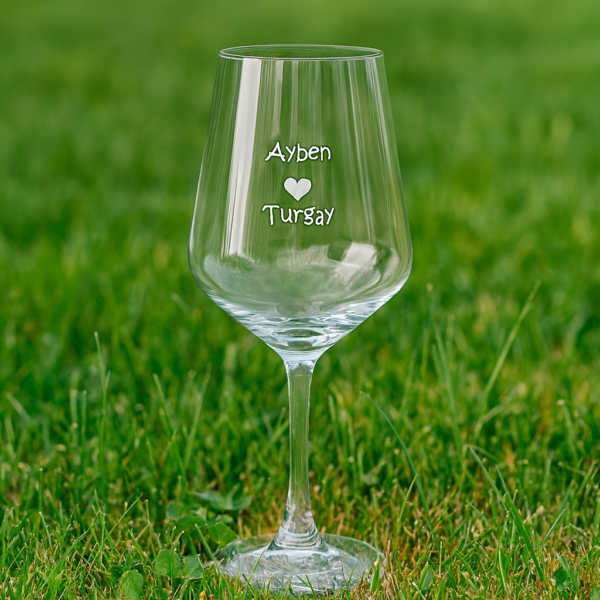 Elegant clear 465 ml wine glasses filled with red wine, laser engraved with custom names and a heart design, displayed on a dining table with flowers, plates, and a wine bottle—perfect personalized gift for Mother’s Day, birthdays, weddings, anniversaries, and special occasions.