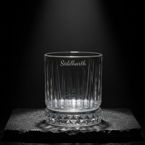 Best2U Personalized Crystal Whiskey Glass with custom name engraving “Siddharth.” This 330ml glass features a sophisticated vertical line pattern and a diamond-cut base that reflects light elegantly. Crafted from premium crystal, the glass combines clarity and durability, making it ideal for whiskey, scotch, or bourbon. The deep engraving ensures the name remains permanent, while the classic design enhances any home bar setting.