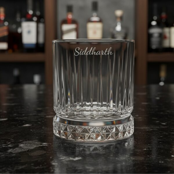 Best2U Personalized Crystal Whiskey Glass with custom name engraving “Siddharth.” This 330ml glass features a sophisticated vertical line pattern and a diamond-cut base that reflects light elegantly. Crafted from premium crystal, the glass combines clarity and durability, making it ideal for whiskey, scotch, or bourbon. The deep engraving ensures the name remains permanent, while the classic design enhances any home bar setting.