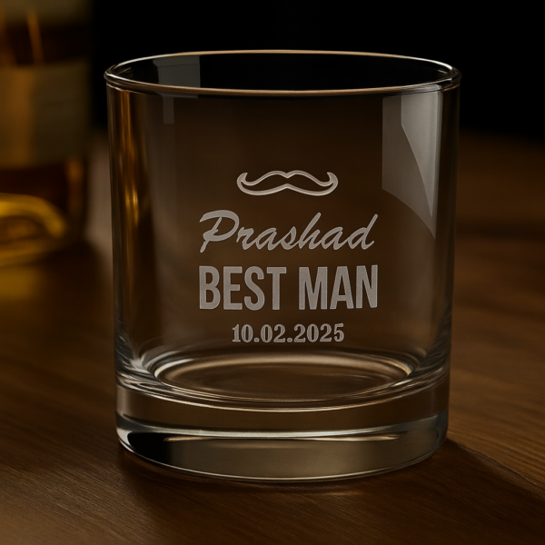 Personalized whiskey glass engraved with a mustache design, the name 'Prashad', text 'BEST MAN', and the date 10.02.2025, displayed on a wooden surface with a warm background