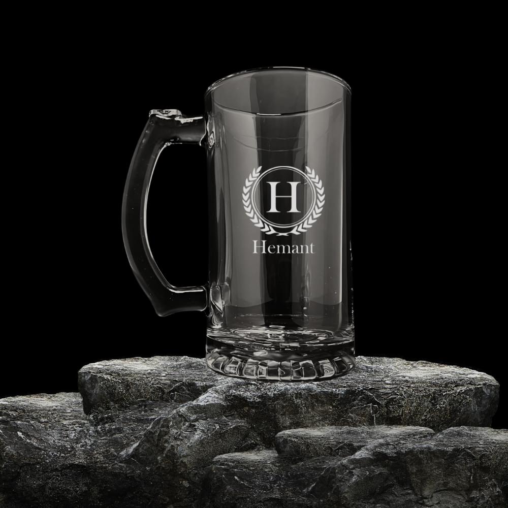 Elevate your drinking experience with this exquisitely crafted personalised beer mug. This premium glass vessel features elegant monogram engraving with a sophisticated laurel wreath design, complemented by customised name etching. The sturdy construction boasts a comfortable grip handle and a solid base that ensures stability. Perfect for serving your favourite brew, this generous-sized mug adds a touch of distinction to any drinking occasion. The crystal-clear glass showcases your beverage beautifully while making a thoughtful, personalised gift for special occasions, celebrations, or corporate events. The classic design combines timeless appeal with modern personalisation, making each mug uniquely special to its owner. The deep etching ensures the personalisation remains clear and lasting. Whether used for casual gatherings or formal celebrations, this personalised beer mug transforms ordinary moments into memorable experiences.